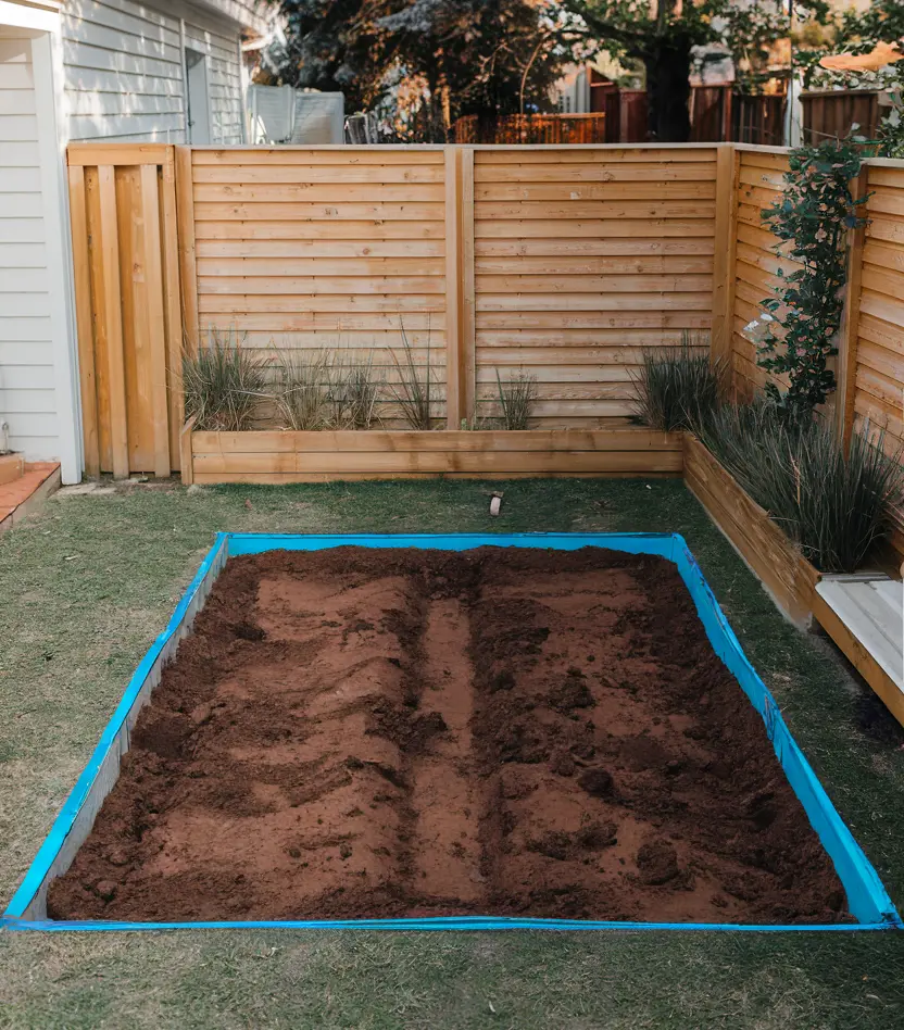 the second step in building an outdoor dog potty area. a small layer of soil is dug in the designated area